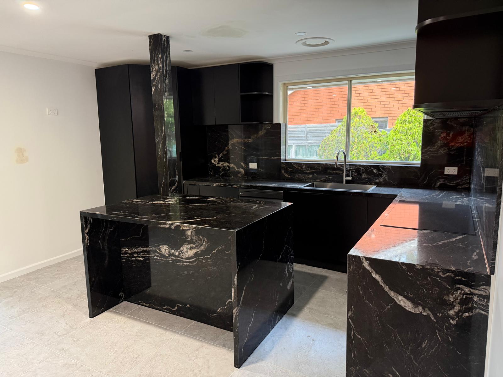 Matte black kitchen with granite splashback